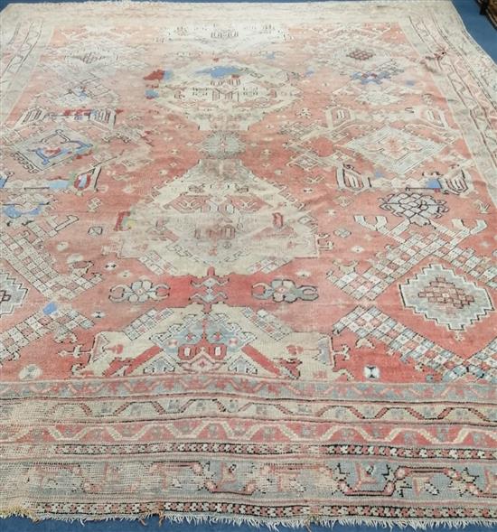 A Turkish red ground carpet 380 x 321cm (worn)